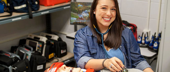 Female EMT with CPR dummy.