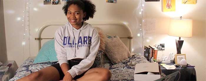 Dillard sophomore Khaelyn Jackson on bed with laptop and study materials.