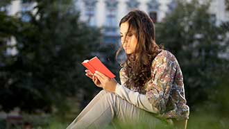 Stock art - student reading outdoors on campus