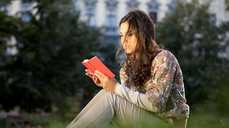 Stock art: Student reading outdoors on campus