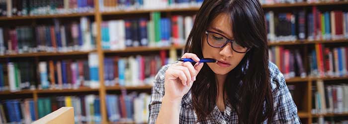 Stock photo: female student studying, pencil in mouth