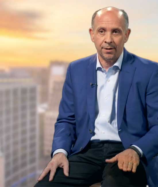 Video still of Lumina President and CEO Jamie Merisotis with a backdrop of the downtown Indianapolis skyline.