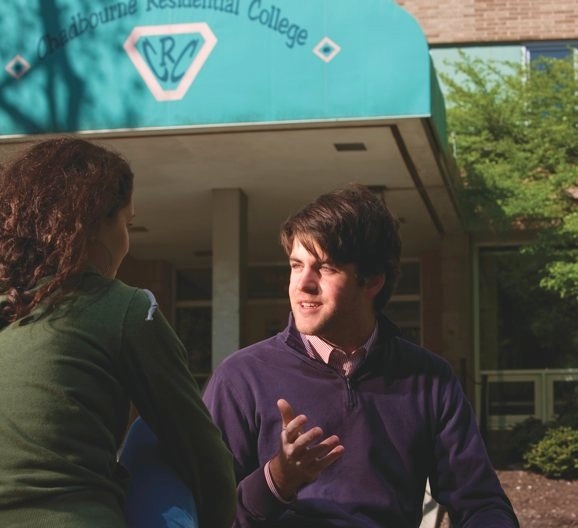 University of Wisconsin graduate John Fink talking with a colleague outside a Chadbourne Residential College building.