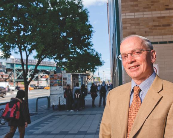 Paul Arcario, dean of academic affairs at LaGuardia Community College in a suitcoat and tie, photographed outside on a public street.