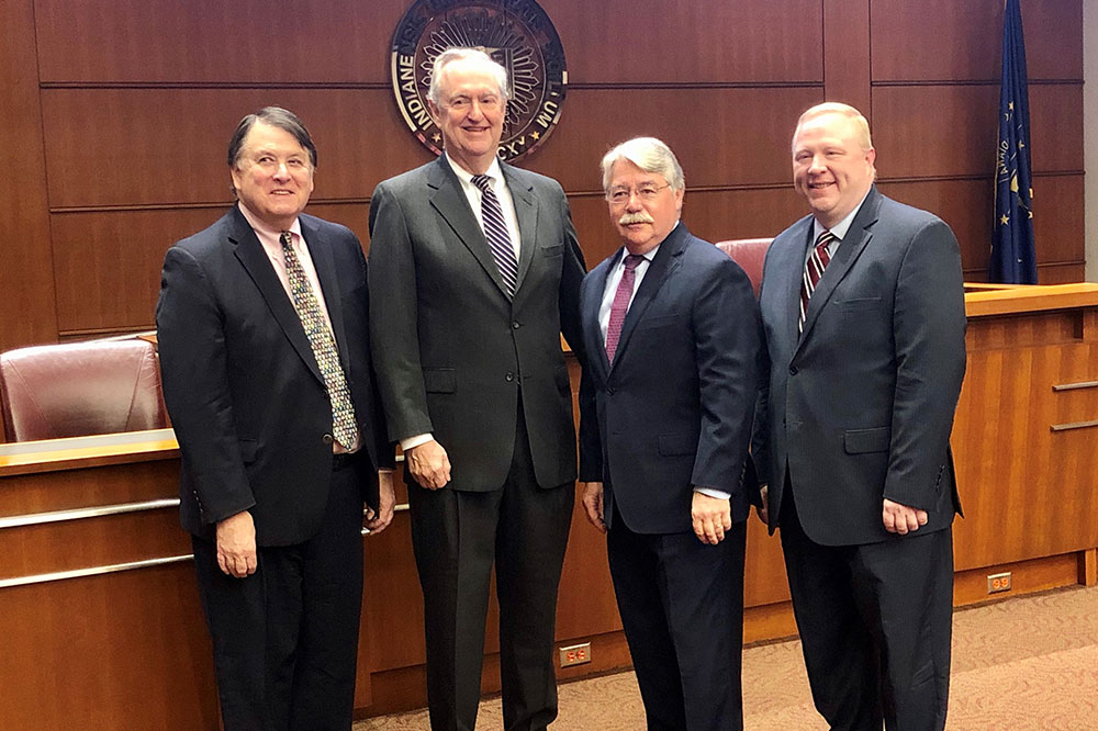 Four older gentlemen in suits.