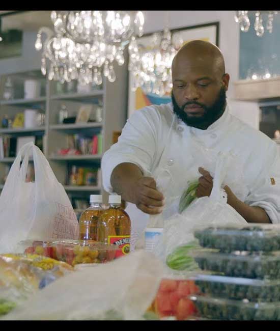 Black prep cook unpacking produce.