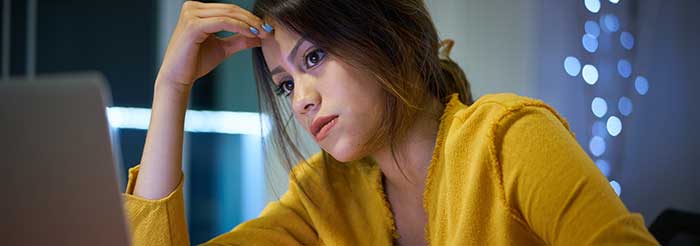 Distraught female student with her hand on her forehead