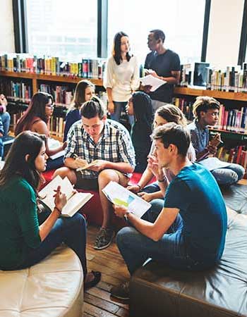 Students circled and studying in a library.