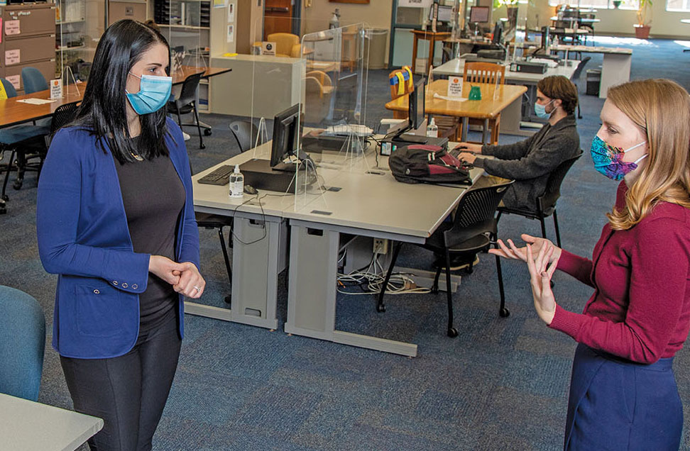 Inside the Academic Services center: two of its directors chat in COVID masks.