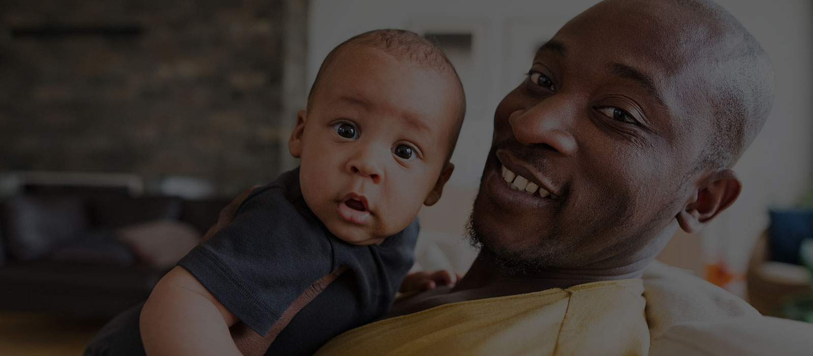 Black father and son, looking directly at you.