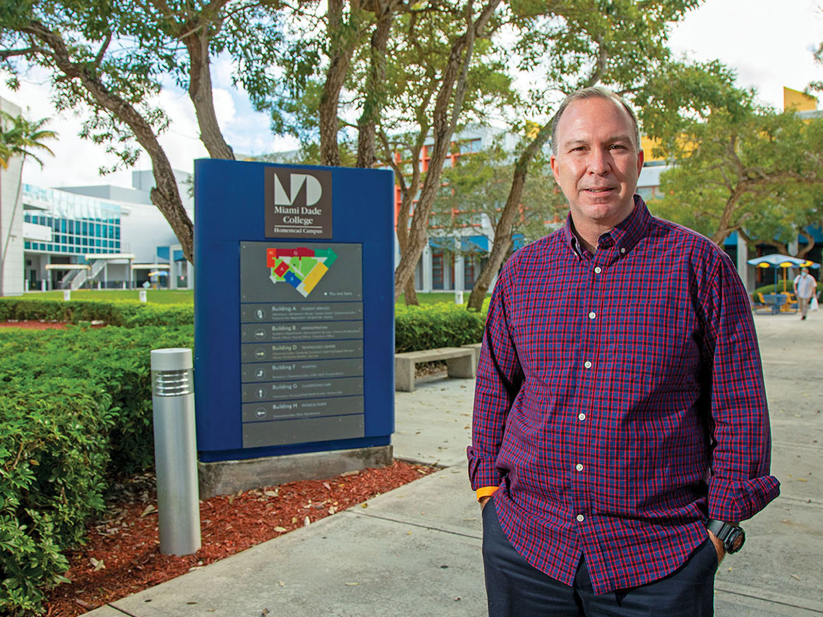 Gustavo Cuervo in a purple plaid shirt on the Miami Dade campus.