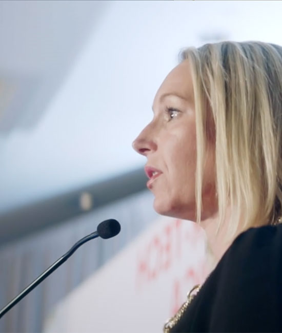 Megan speaking at a lectern.