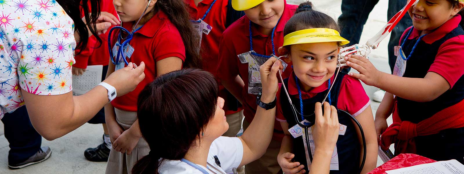 Kindergartener Shayleene Barrera, 5, listens to her heartbeat as she and her classmates attend the annual Kinder Caminata (“path from kindergarten”) event at Santa Ana College. Over two decades, Kinder Caminata has introduced thousands of underserved students in Santa Ana schools – and their families – to the campus and the college-going culture.