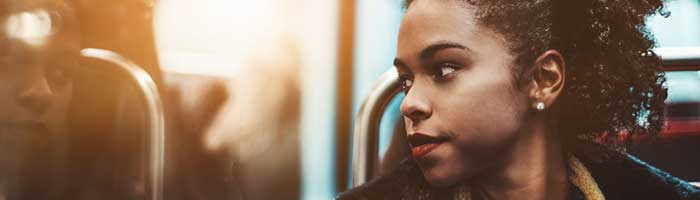 This is a photo of a female college student looking out the window of a subway car.