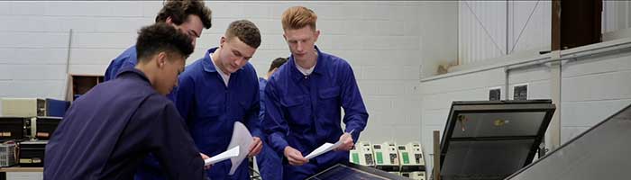 3 men work together in a factory setting