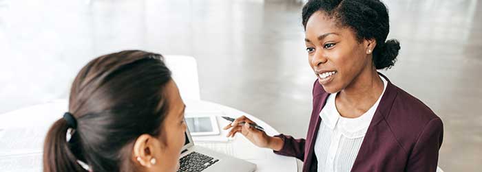 Two women work together in an office environment.