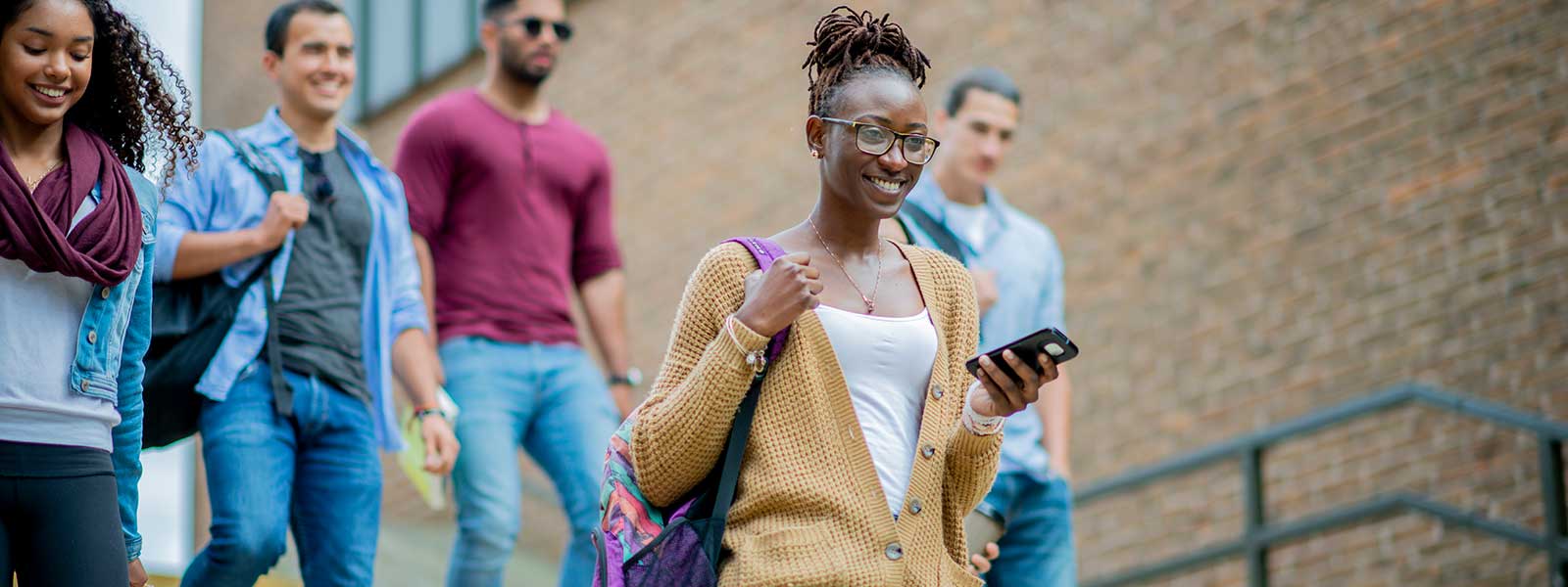 Students walking down the steps in a city college environment.
