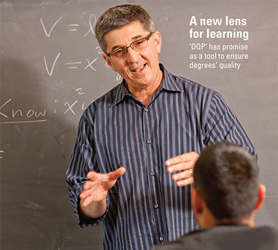 Michael Semenoff, an adjunct professor of mathematics and director of institutional research at Marymount College in front of a blackboard instructing students.