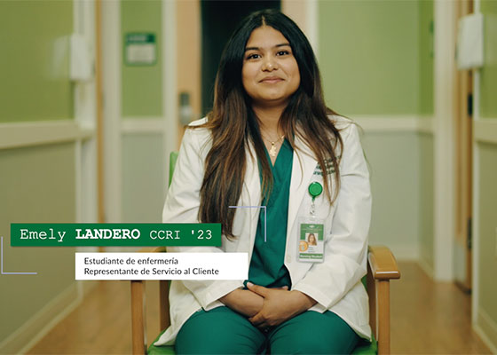 Featured student from video in green medical uniform seated.