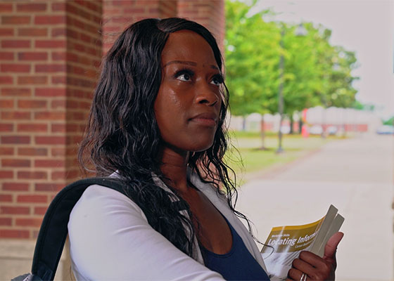 Woman fearful with self doubt about entering new college building for the first time.