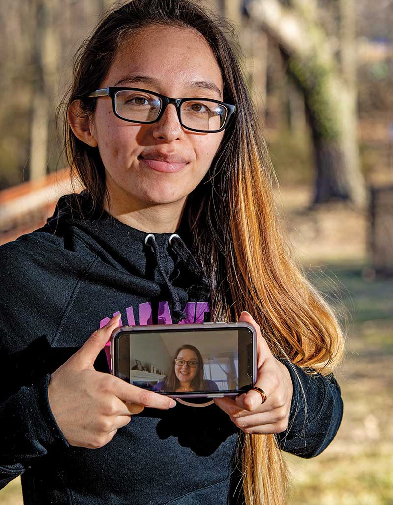 Josseline Cruz holding up a phone with a Facetime screen.