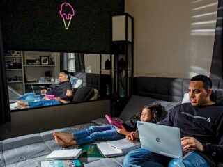 Father and daughter study together in bed.
