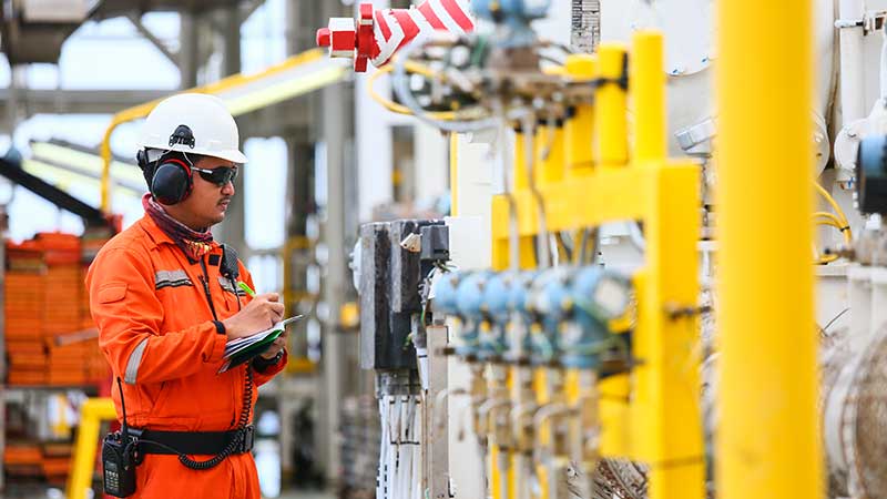 Oil rig worker performing an inspection.