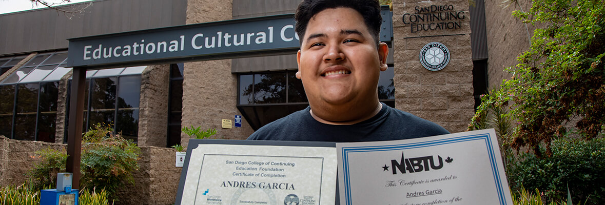 Andres Garcia stands in front of the Educational Cultural Center in San Diego, Calif. with his two certificates.