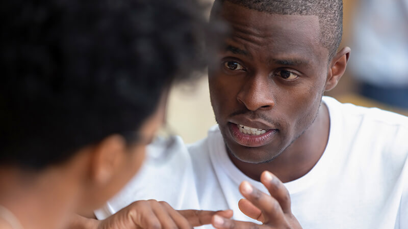 Two men talk face to face in close proximity.