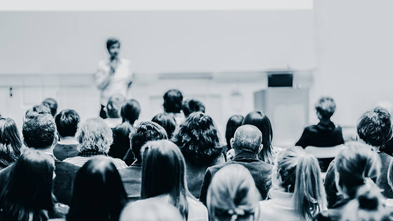 Woman giving presentation in lecture hall at university. stock photo