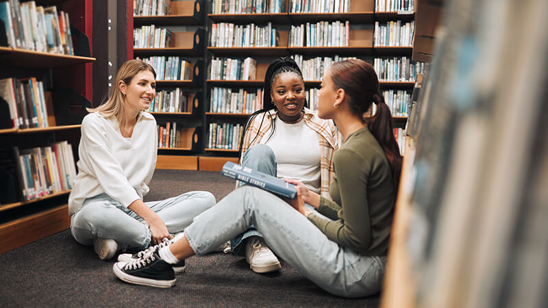 Students sitting on floor of library