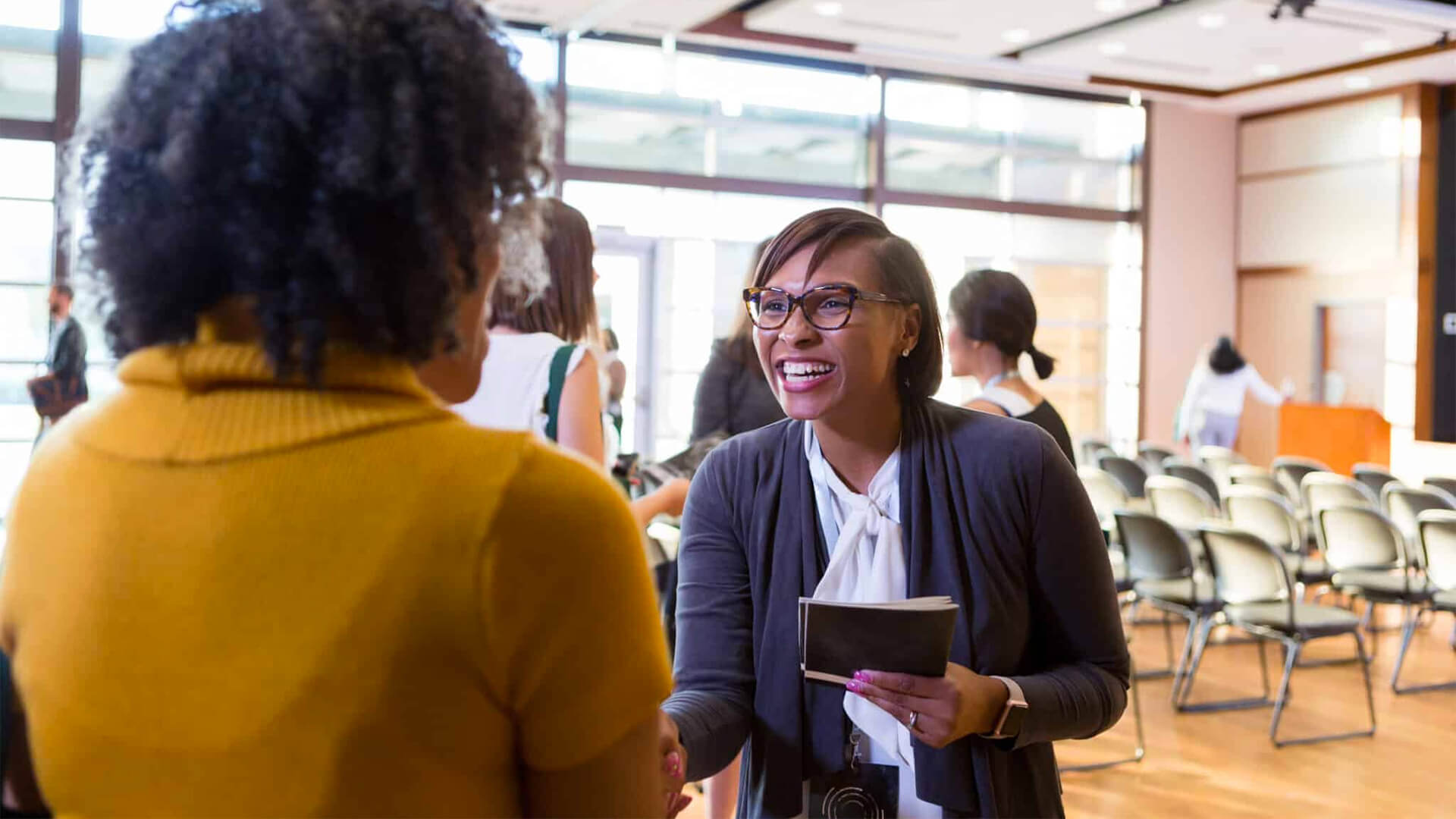 Adult student shaking someone's hand with a ridiculous amount of enthusiasm