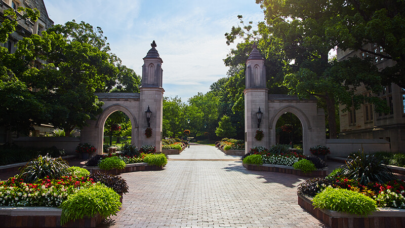 Welcome to Indiana University in Bloomington with brick boardwalk through Sample Gates stock photo