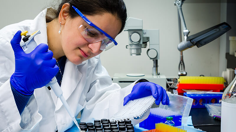 A woman conducts research in a laboratory. iStock